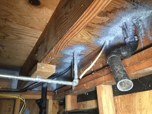 Leaks low on the building included penetrations through the floor that pulled air up from the crawlspace because of stack effect.