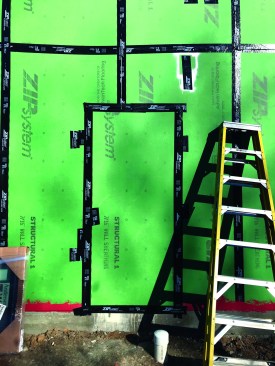 When the frame is  complete, they’ll come back, fill in doors they left open for access, and run their initial blower-door test. Note the white spray  paint above the door. All temporary nailers are painted white for easy identification so they can be filled prior to the test.