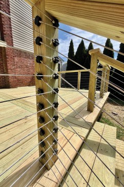 Each angled stair-rail cable passes under the corresponding level cable on the deck.