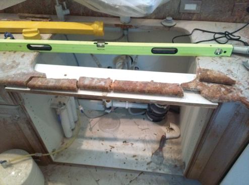 A piece of melamine reinforced with a 1-by supports the granite pieces while they are being glued together.