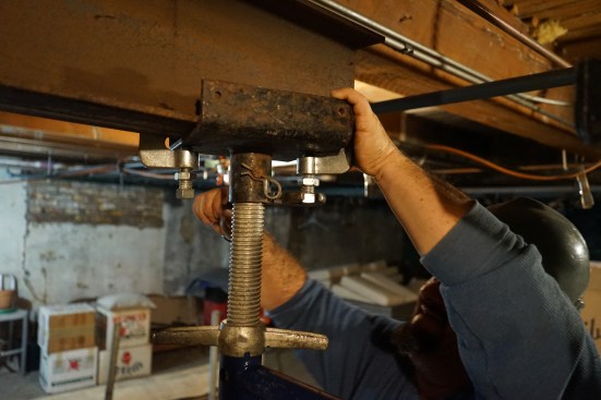 Clamps secure the steel beam sections to U-heads on the shoring frames.