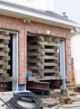 At the garage, where there's no sill, cradles had to be extended to the garage door header, and the front porch had to be supported on cross beams built out on cantilevered sections of steel.