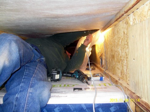 Builder Chris Miksic installs moisture probes in the wood I-joist roof framing for an unvented flat roof. This cavity would later be insulated with dense-blown cellulose.