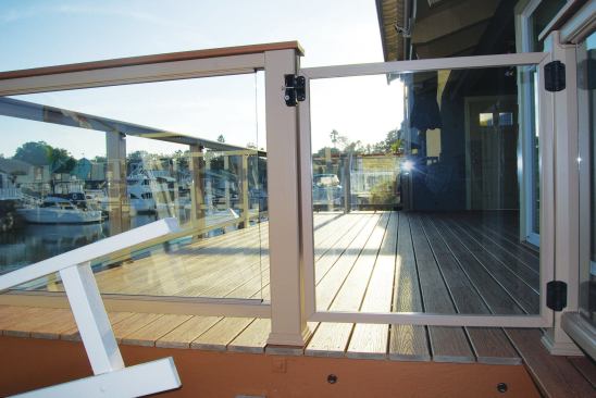 A heavy glass gate leads onto the deck. The gate post on the right side of the photo can be easily adjusted if expansion or contraction of the deck materials causes the framing to shift.