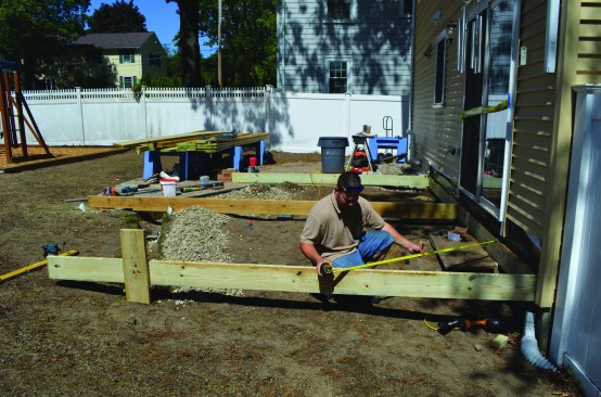 The crew squared the end joists to the house and established the desired pitch for the deck.