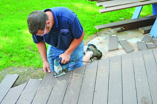 A worker laid out the curved portion of the decking, then carefully cut to the line with a jigsaw.