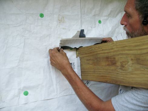 After removing the narrow strip of release paper from the second piece of flashing tape, I center the tape on the joist and bond it around the top half, so that the upper legs overlap the lower legs.