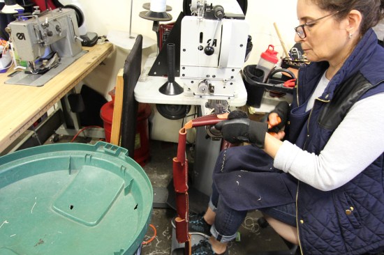 This seamster is stitching flat pieces of leather into tool holders. It's faster to stitch them one after another and leave them connected (like a string of sausages) and then later snip them apart.