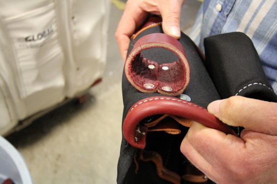 Here is the finished connection between a hammer loop and tool bag. The top of the loop receives the most stress so they put washers under both sides of the rivet in this location.