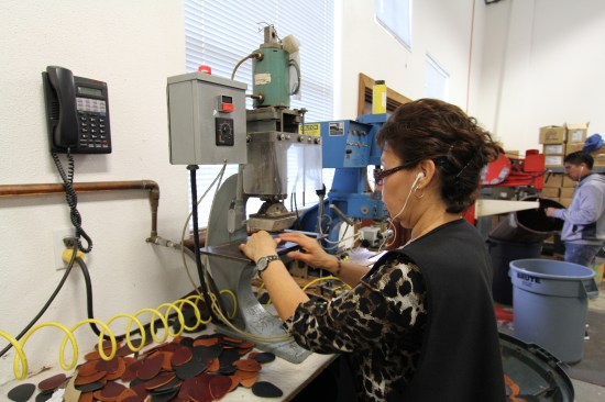 This embossing machine uses heat and pressure to permanently press logos into leather.