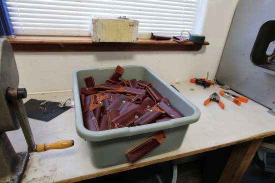 Leather tool holders stitched, riveted, and ready to install on tool belts. Note the holder screwed to the side of the bin; it's there as a reference to what goes inside.