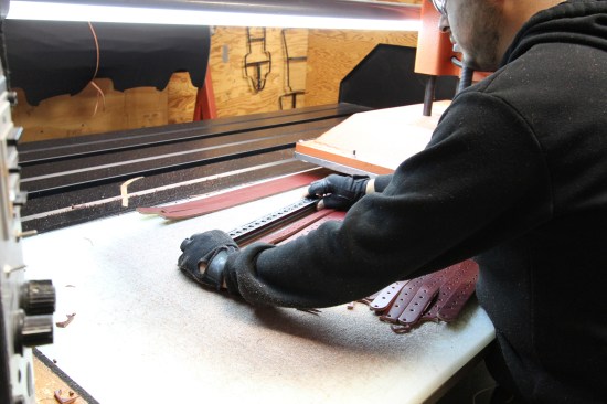 The press operator places a die over the piece of leather that is to be cut...