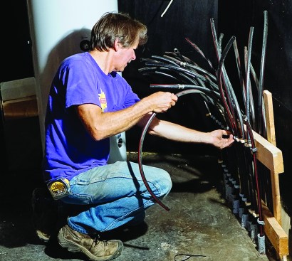 ReVision Energy’s Chris Blaisdell works on the hydronic tubing for a radiant slab in a
custom house. Behind him is the hydronic buffer tank for the system.