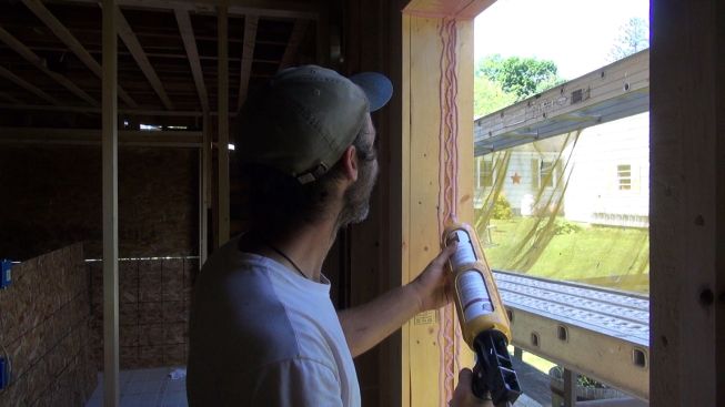 Kelly applies Prosoco Joint and Seam Filler to a rough window jamb.