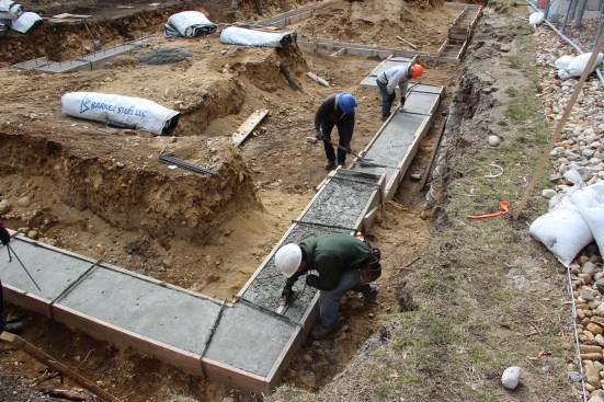 Masons for JB Concrete Foundationsd (Bridgton, Maine) work on a footing pour on a tight site for Great Falls Construction in Portland, Maine's busy Munjoy Hill neighborhood.
