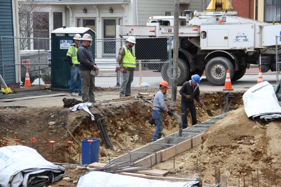 Concrete masons with JB Concrete Foundations (Bridgton, Maine) place footings for a multifamily infill project in Portland, Maine in February. Access to the tight site is limited, but a concrete pump and boom helped the work go quickly.