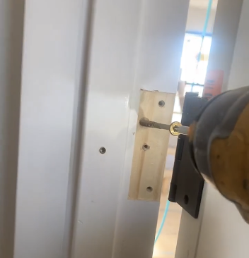 With the jamb plumb, the author adds structural screws behind the hinges to take the weight of the door.