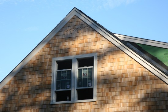 7:16a: South wall all shingled and sporting the Habitat logo in the gable.