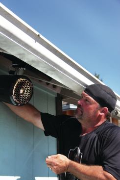 The author installed speakers that were designed for mounting on a wakeboard boat tower. The speakers are rated for full exposure to weather, with high-density polyethylene enclosures, and are equipped with adjustable aluminum hardware so they can be clamped to round rails.