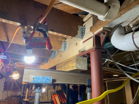 When joists have been notched to sit on a ledger that is replaced with a load-carrying beam, the author begins by infilling the notch in the joists with a block of wood, as shown at left). He then will installs  Simpson HTU hangers, which have an elongated heel made for trusses.