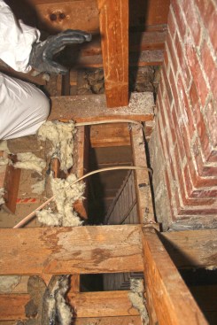 The chimney chase in this older attic communicated directly with the home’s living space and basement below.