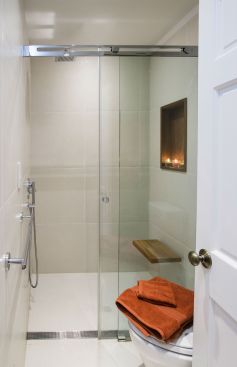 JMA had to move a wall in order to fit the new shower, but a glass door and infinity drain help to make the space appear larger. The same tile is used on the wall and floor to create a fluid design while a teak bench and cubby enhance the room with a spa-like treatment.