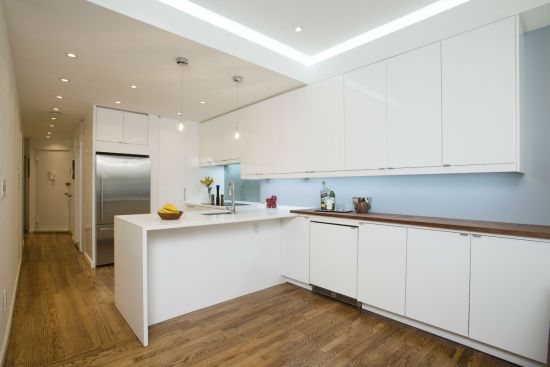 With the walls now gone, the same white cabinetry is allowed to flow from the kitchen to the dining room for a continuous and connected look while a bamboo countertop helps to quietly divide the two areas without imposing on square footage.