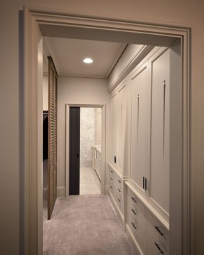 The walkway to the bathroom features a custom linen press cabinet and cypress louvered doors separating the walk-in closet.See the&nbsp;full article&nbsp;about this award-winning project.