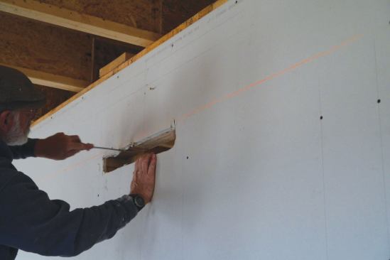 ... and cuts the drywall before installing the bracket.