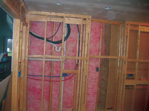 The flexible condensate drain is run inside a diagonal 1 1/2-inch PVC pipe that empties into the DWV line. Note the P trap. Slack in the line set and wire allows maintenance or repair of the head without crimping the copper tubing.