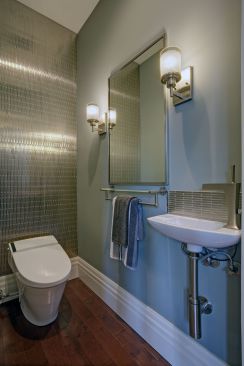 With its metallic tile, steel light and plumbing fixtures with matte finish, and exposed pipes, the guest bath on the first floor of the Painted Lady packs a powerful design punch in a tight space.