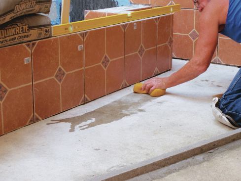 After sweeping the grit from the slab, sponge the site of the mortar screed with clean water to remove dust and to dampen the slab.
