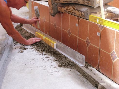 Rest one end of a 6-foot straightedge on the part of the screed that has been compacted, and tap the other end down until the uncompacted part of the screed is at the proper slope and height.