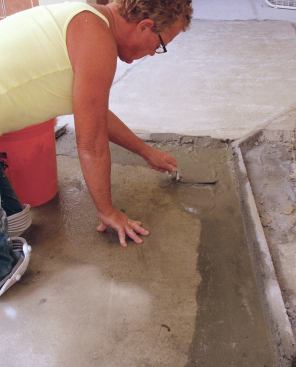 The process for floating the mortar bed is similar to that of creating the screeds. After dampening the dry slab with clean water, apply a thin coating of slurry to the slab and to the side of the screed.