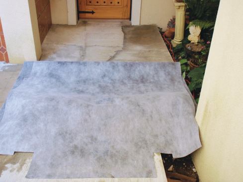 Carefully pull the front edge of the sheet about halfway back to expose the dampened mortar bed.