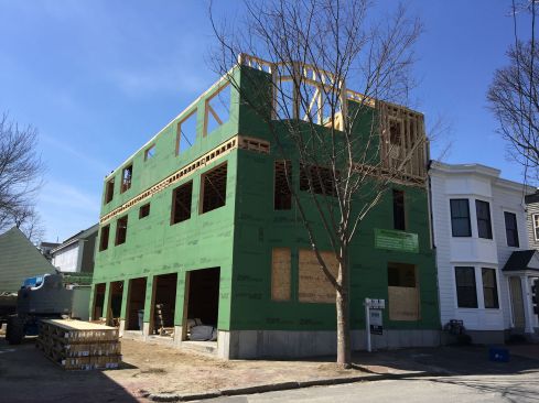 Already three stories tall as seen here, this Portland, Maine multifamily building will rise another story, plus a rooftop patio. It must be isolated from the existing building at right by a two-hour fire-rated assembly.