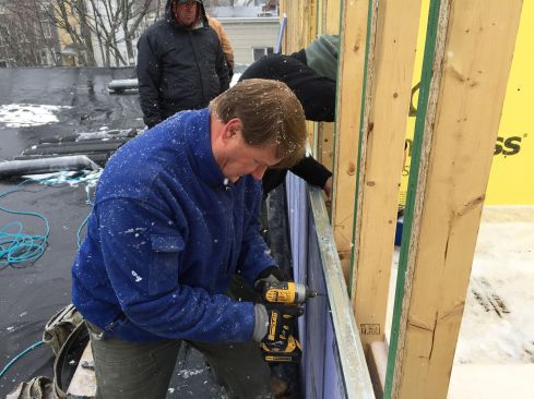 Paisley pins an H-stud to the gypsum board with a one-inch screw.