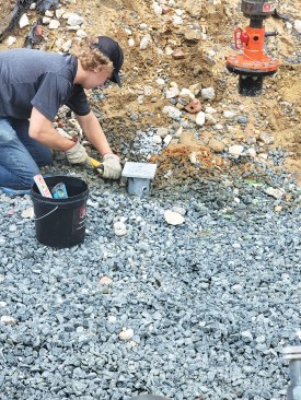 ... a worker bolts a T-cap to the top of the extension.