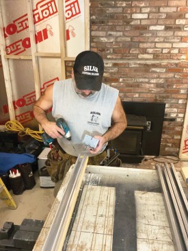 Because a subfloor will be installed over the concrete slab basement floor, the author set up a laser line to establish a benchmark elevation. This frame was sized for a 3'-0" x 6'-8" door, so the author had to cut the frame header to fit the narrower, 2'-8" x 6'-8" door used on this project. He started by unscrewing an end bracket.