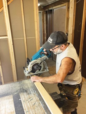 Then he carefully cut the track to length, first cutting the wood header, then flipping the assembly over and cutting the metal track 1 3/8 inches shorter than the wood header.