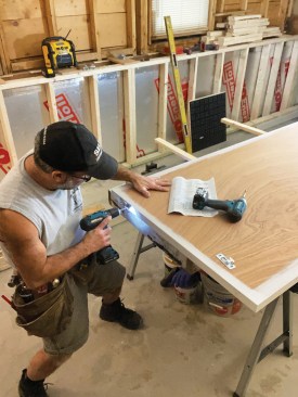 The second pair of split steel studs was installed in the same manner midway between the end pair and the trimmer. Prior to installing hardware and mounting the door onto the track, the author primed and painted the edges of the solid-core door, then mounted the two door plates on the top edge of the door 2 3/4 inches from the edges.