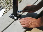 Anchor bolts drop through the holes at the corners of the base of the Secure-Mount, while the smaller holes in the edges are threaded for the adjusting screws that are used to plumb the post.