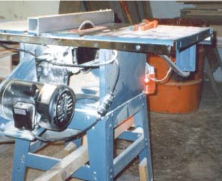 After his accident, the author equipped his table saw with a clearly visible running light; now he knows if the saw is on even when he’s wearing hearing protection. Note the absence of a blade guard between the underside of the saw’s blade and its dust-collection port.