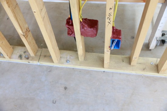 Putty Pads installed on outlets. Notice the staggered 2×4 studs with a 2×6 base plate.