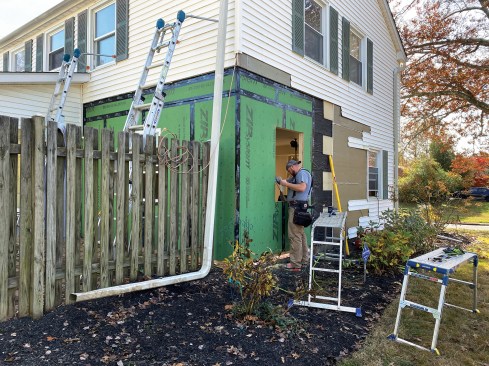 The crew installed new Zip System sheathing followed by a layer of 2-inch-thick rigid foam insulation to match the thickness of the existing lap panel siding and existing foam insulation underneath the vinyl siding.