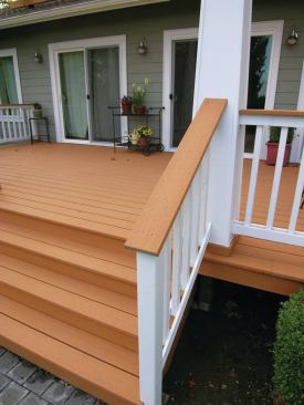 The painted rail posts, balusters, and tapered pergola columns contrast nicely with the composite decking and naturally-finished cedar pergola beams and rafters.  