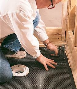 A layer of 15-lb. tar paper and galvanized expanded metal lath (2.5 lb. per sq. yd. or heavier) is stapled to the subfloor.