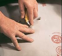 To fit the membrane around the clamping drain, first cut small holes for the flange bolts and push the membrane over the protruding bolts.