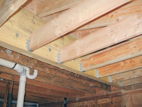 Once the house wall was removed, they added ceiling joists flush with the existing ones on the other side of the beam.