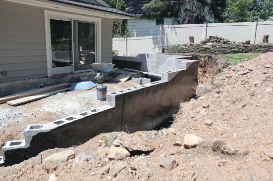 Portland-cement plaster and a coat of tar makes the wall water-resistant and prepares it for stone veneer.